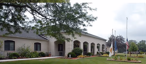 Exterior view of Life Care Center of Rochester with arched entry and landscaped front lawn.