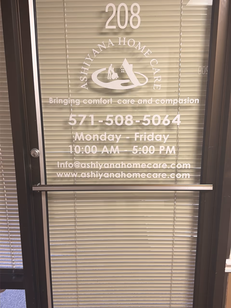 Glass door with blinds displaying Ashiyana Home Care branding and contact details.