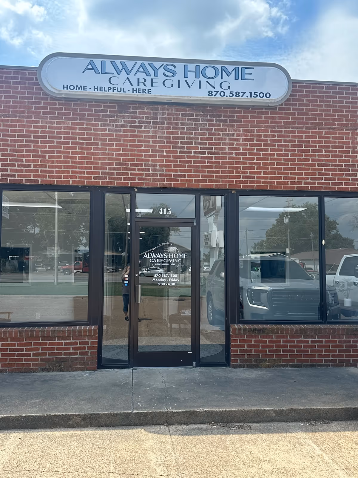 Brick storefront with Always Home Caregiving sign above glass entrance.