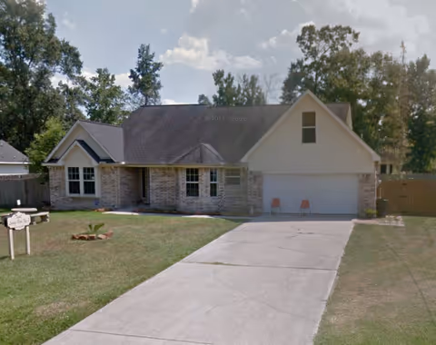 Front exterior of a single-story senior living facility with a two-car garage.