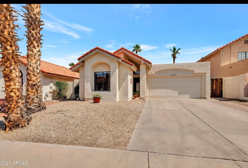 Front exterior of a desert-style house with a two-car garage.