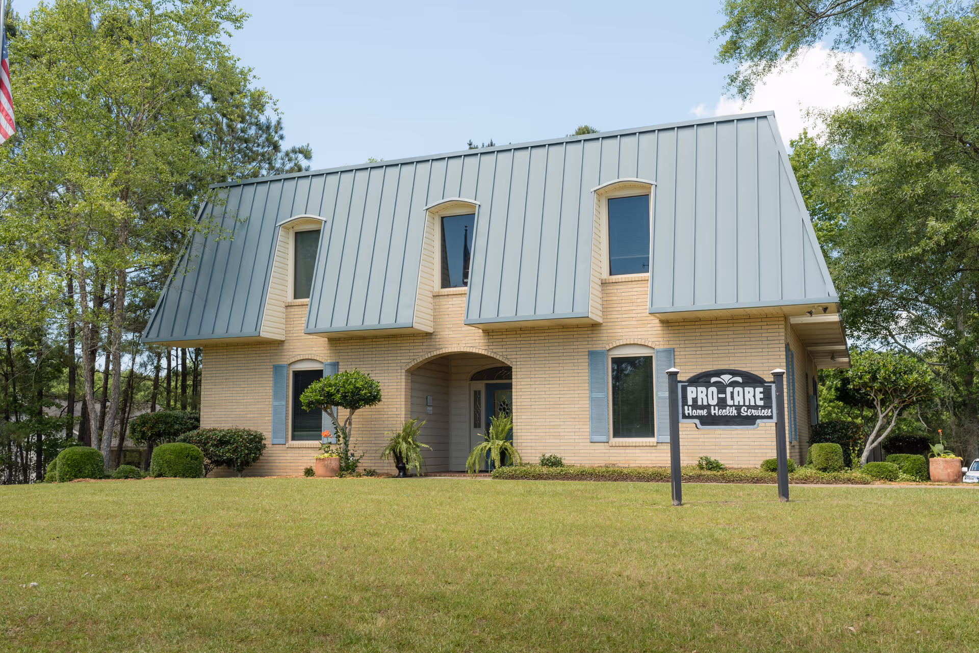 Exterior of a brick facility with a tall metal roof and PRO-CORE Home Health Services sign.