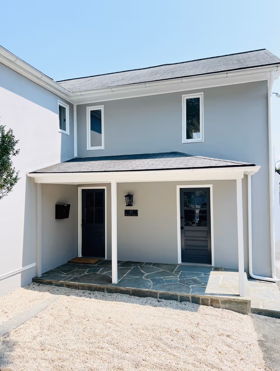 Modern two-story building with a small covered entrance porch and two front doors.