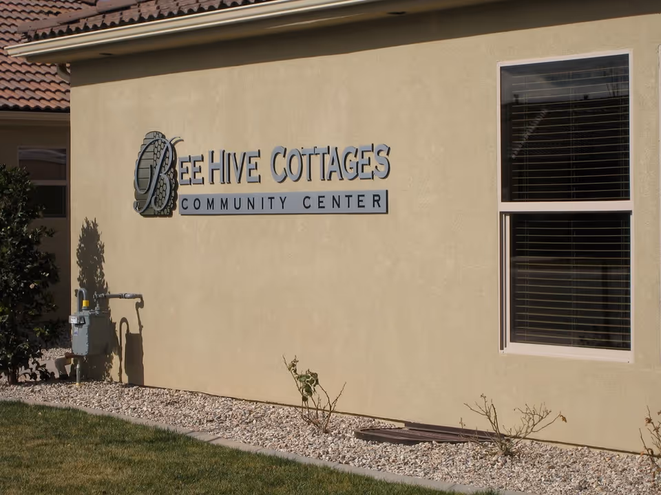 Exterior wall of BeeHive Cottages Community Center with sign.