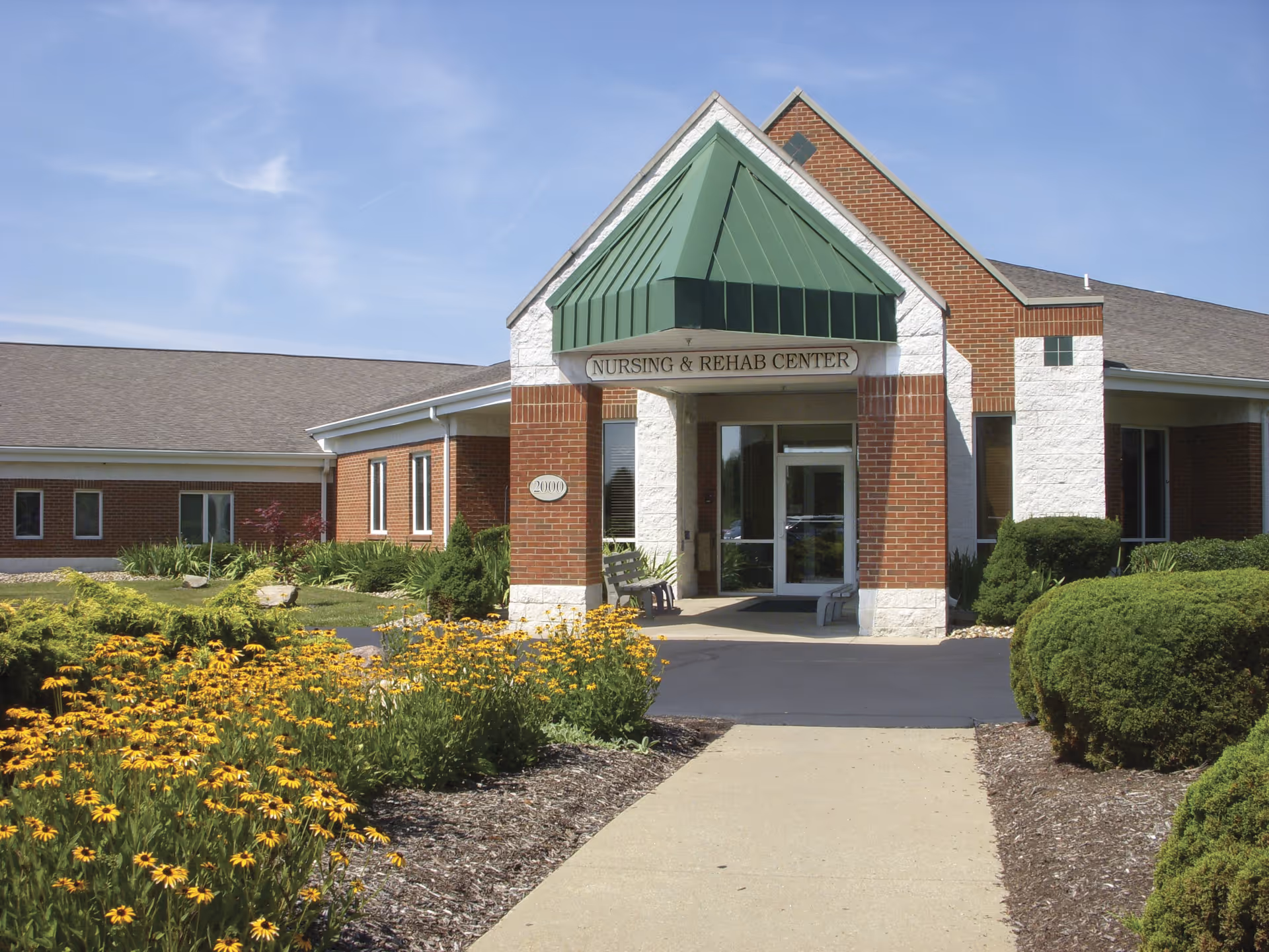 Exterior view of Brethren Care Village nursing center entrance with green awning.