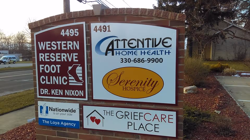 Outdoor brick sign displaying Attentive Home Health, Serenity Hospice, and GriefCare Place logos.