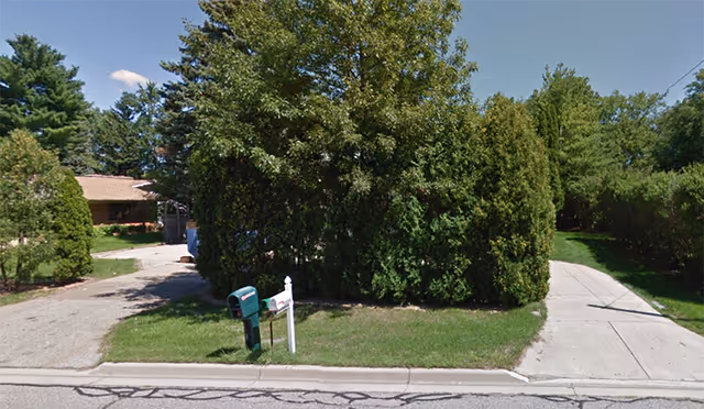 Exterior view of Kalkidan AFC 2 facility with hedges, mailbox, and sidewalk along the street