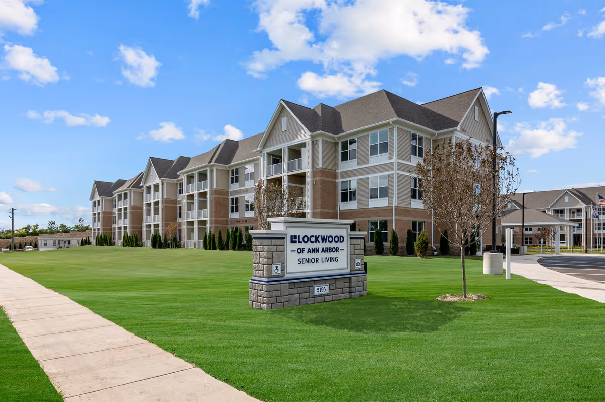 Large senior living facility with manicured lawn and a sign reading Lockwood of Ann Arbor.