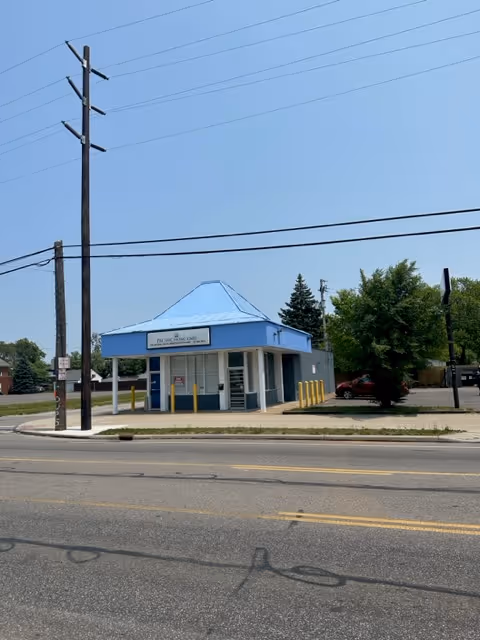 Small light-blue building with a blue roof on a street, Pacific Home Care, LLC sign.