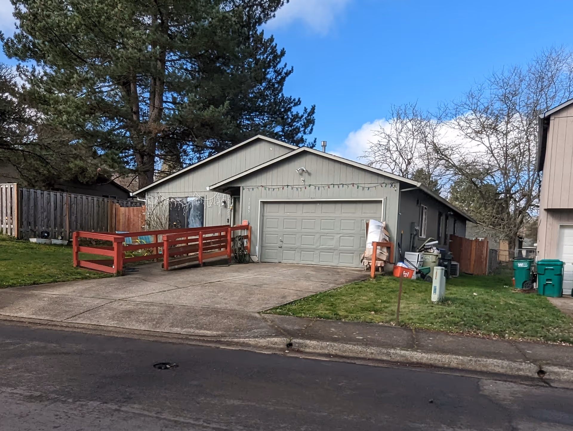 Exterior view of a single-story home with a two-car garage and red railing.