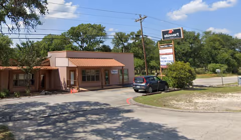 Exterior view of Senior Helpers Texas Hill Country facility with a stucco building and sign.