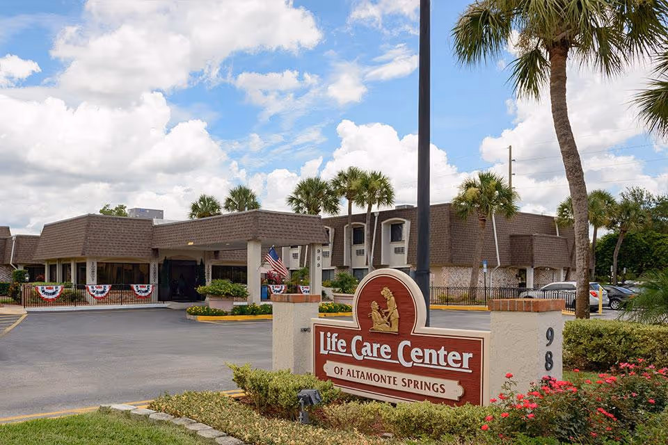Exterior view of Life Care Center of Altamonte Springs with sign and palm trees.