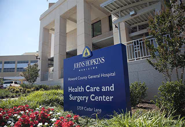 Exterior view of Johns Hopkins Health Care and Surgery Center sign at the building entrance.