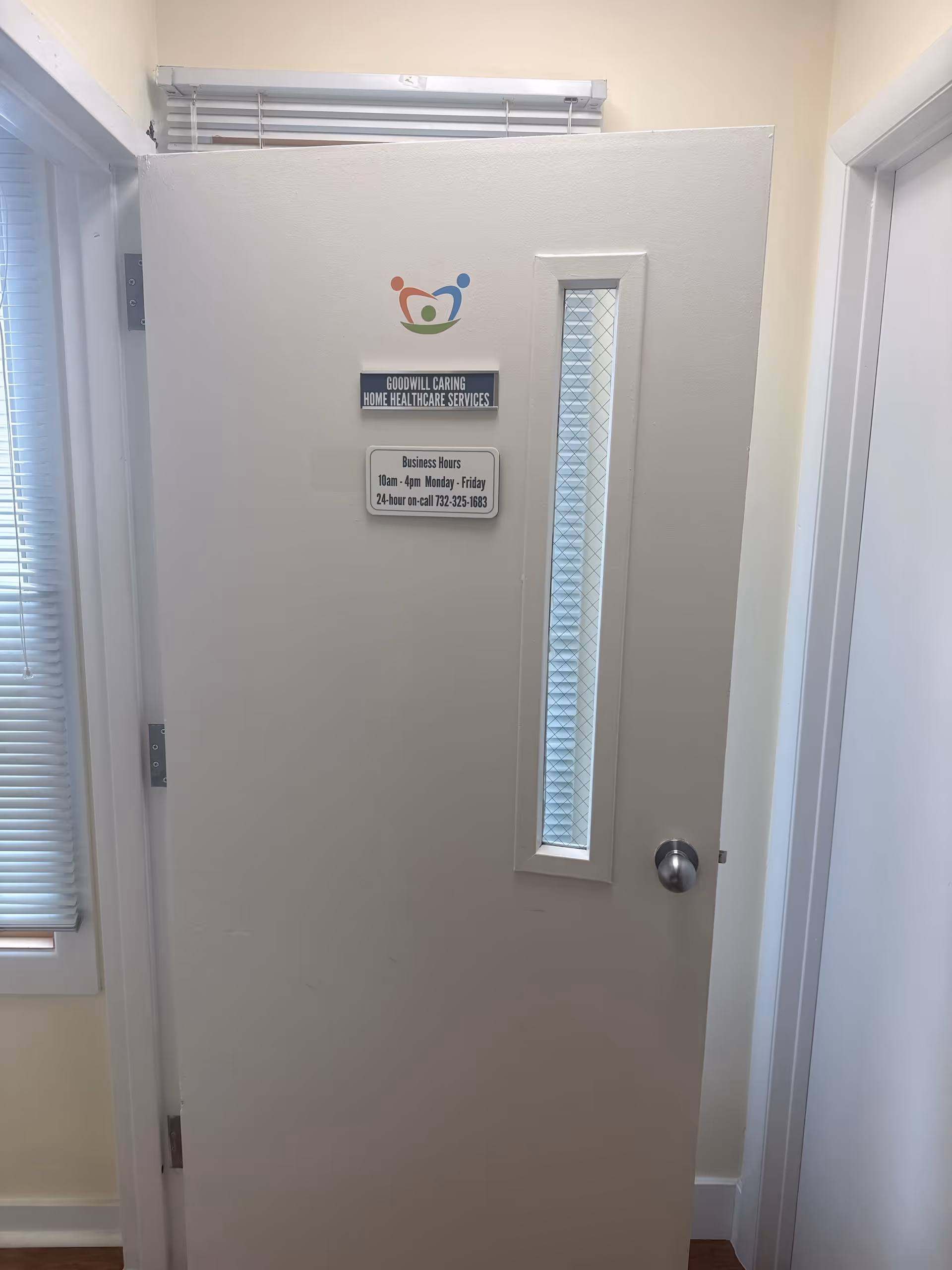 Interior doorway with a logo sign and business hours for Goodwill Caring Healthcare Services.