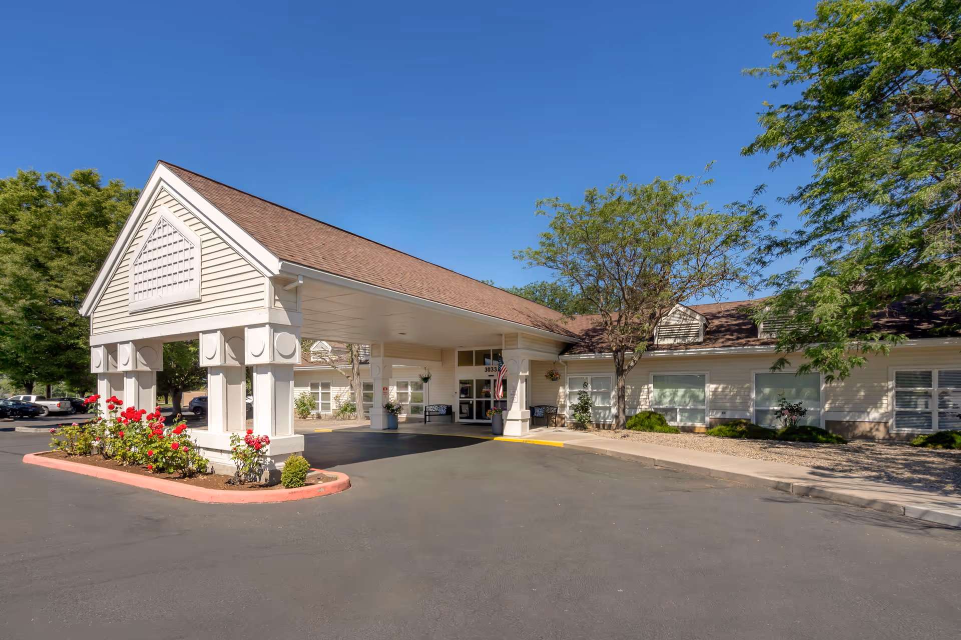 A senior living facility with a welcoming entrance and flower landscaping.