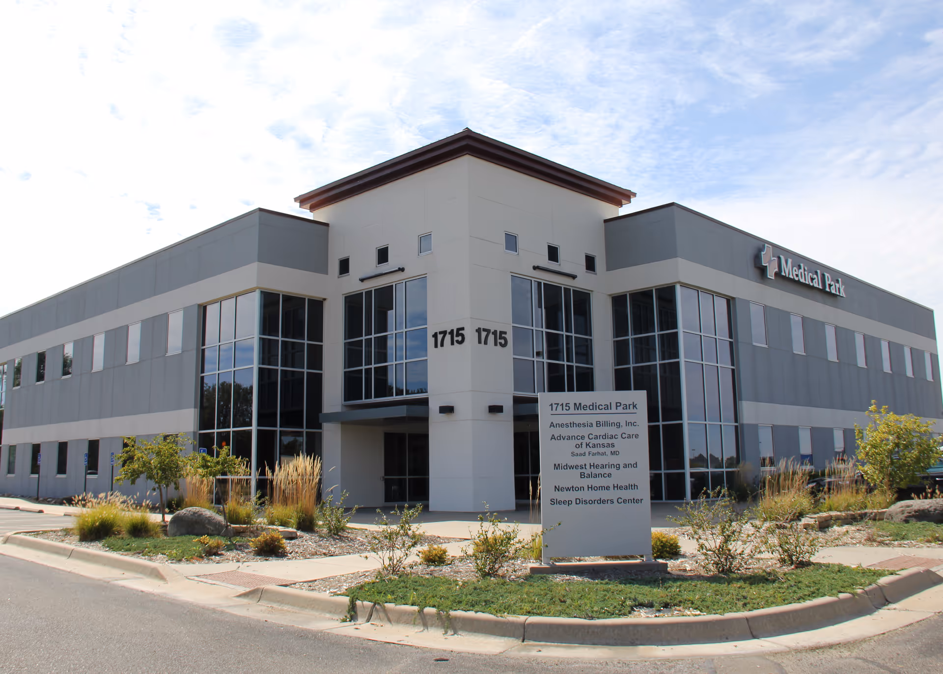 Exterior of a two-story medical facility with glass entry and landscaped frontage.