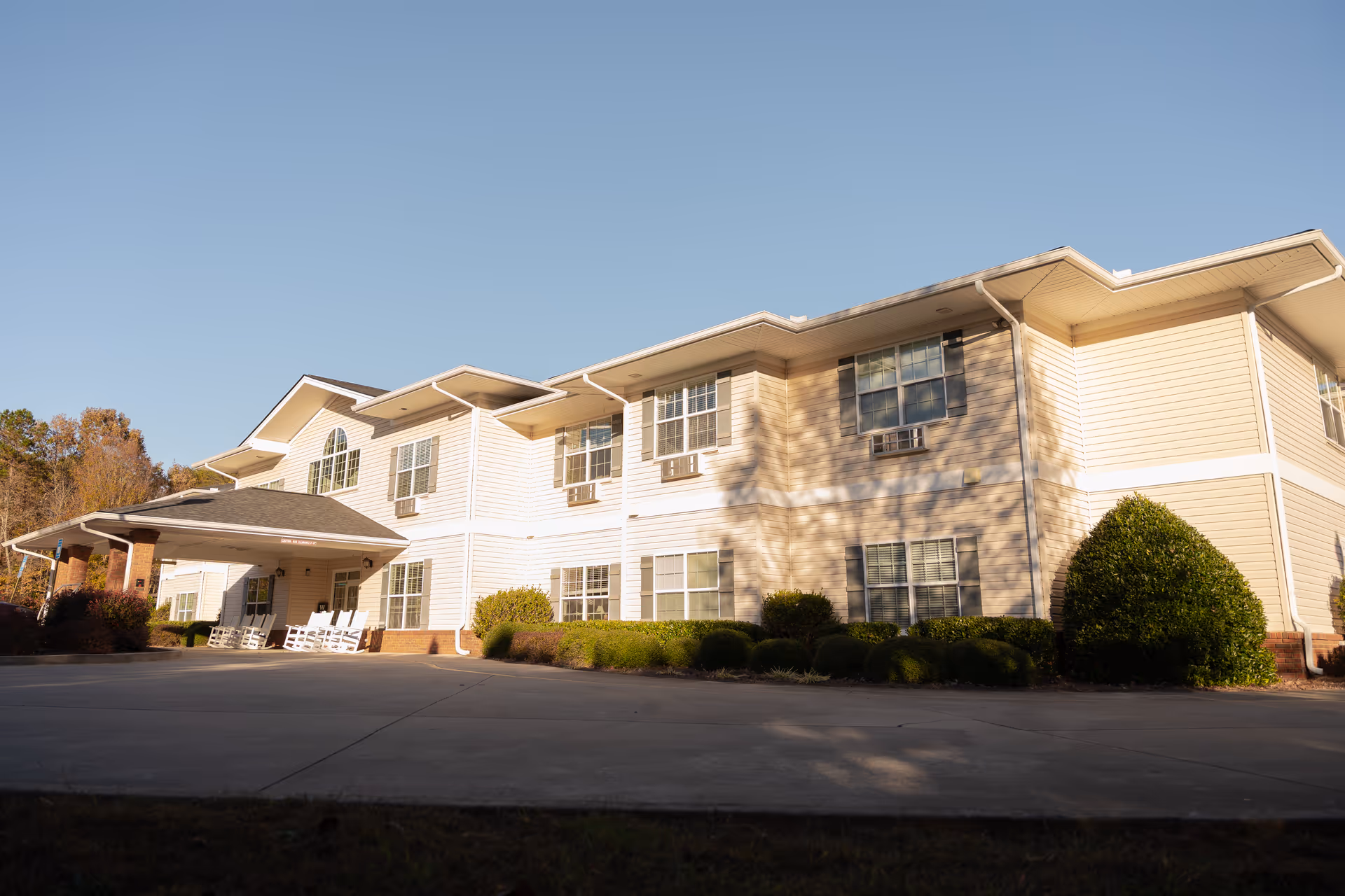 Two-story Oaks at Ellijay senior living facility with beige siding and a covered entrance.