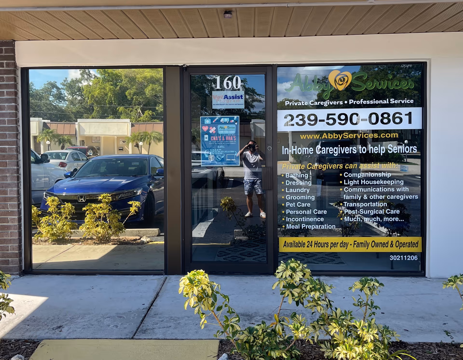 Storefront for Abby Services In-Home Care with a large phone number on the glass door.