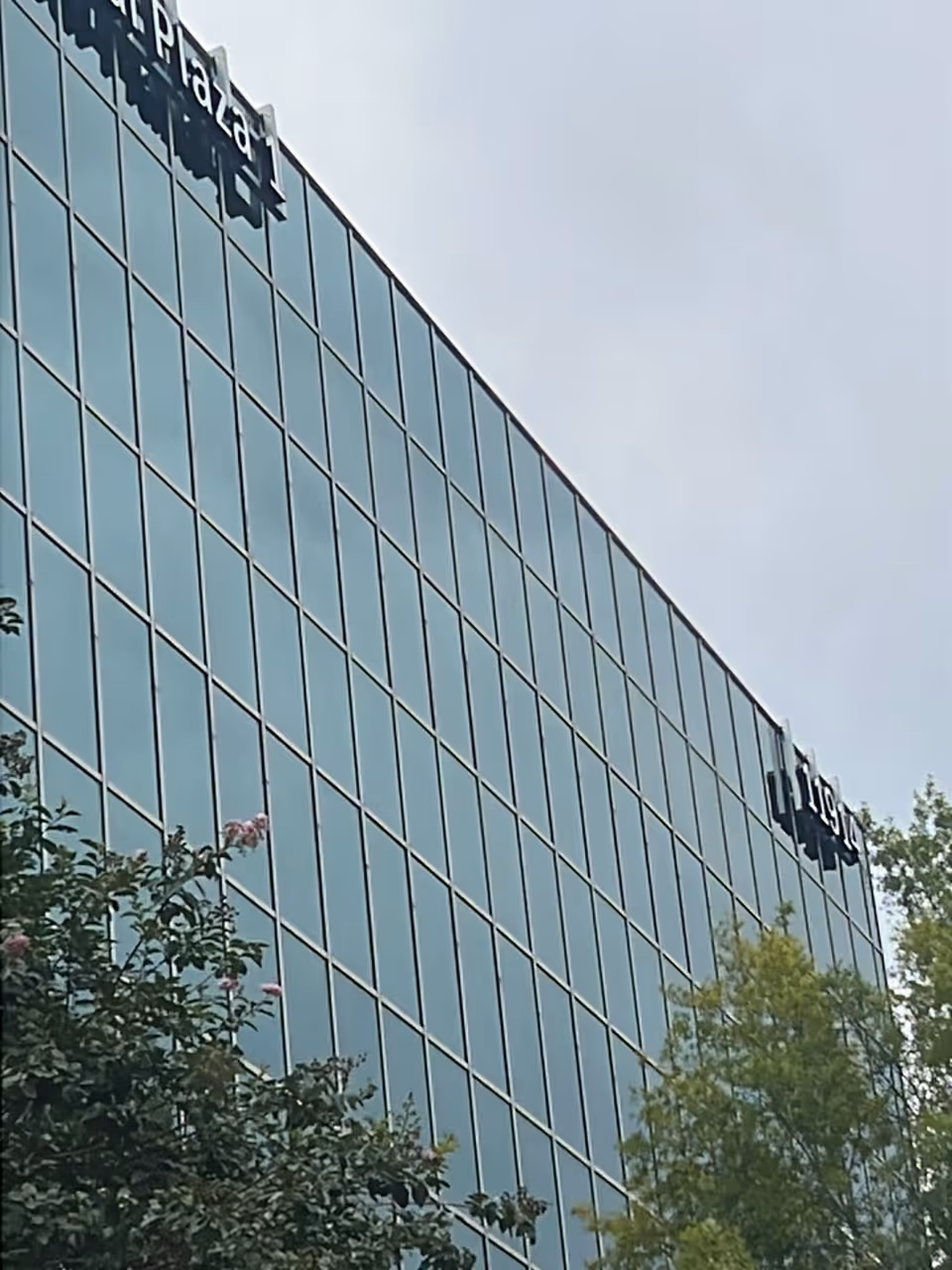 Glass-clad building exterior with Memorial Hermann signage and surrounding trees.