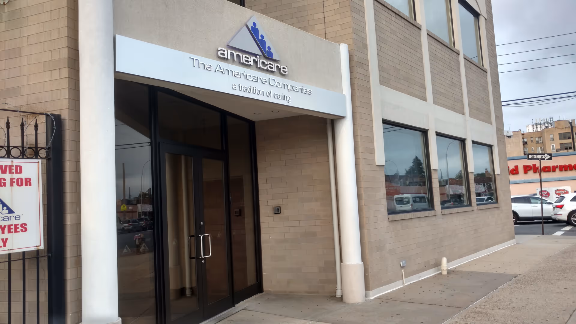 Exterior view of Americare facility entrance with glass doors and building signage.
