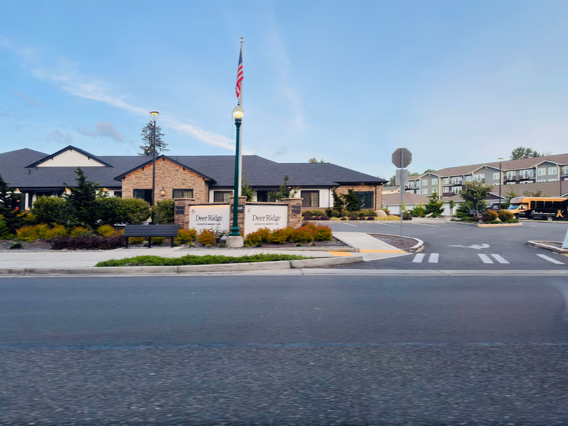 Exterior view of Deer Ridge Memory Care Community with sign and landscaped entrance.