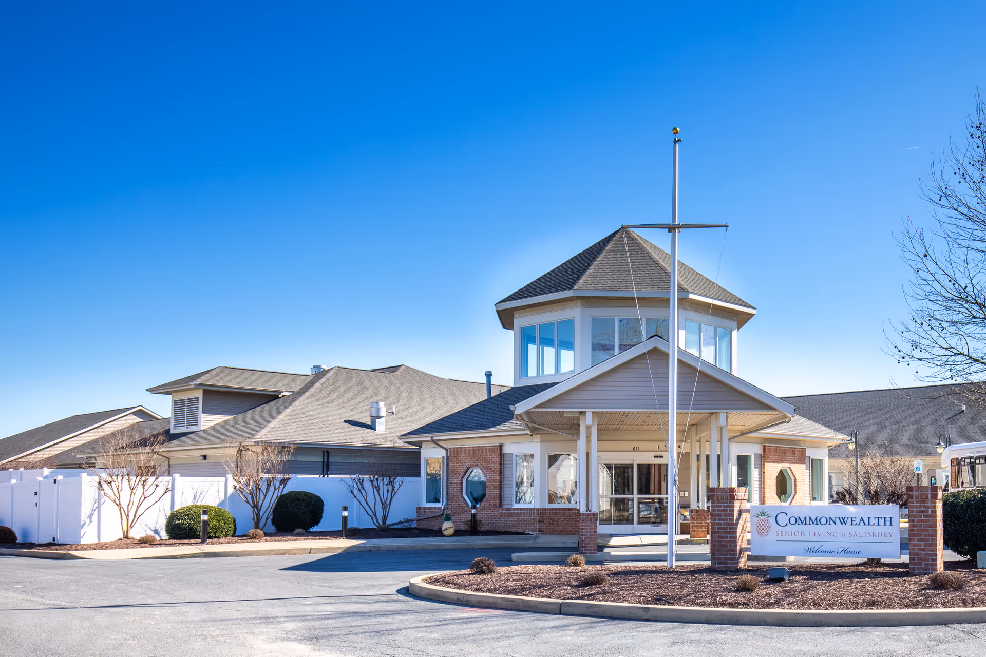 Front view of Commonwealth Senior Living at Salisbury entrance with sign and clear blue sky.