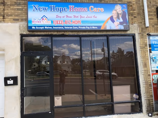 Front exterior of New Hope Home Care storefront with glass doors and sign