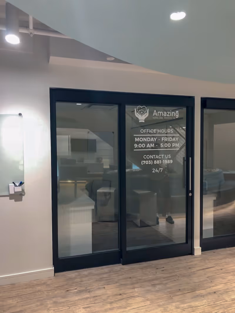 Interior hallway with glass doors labeled Amazing Home Care Services VA and office area.