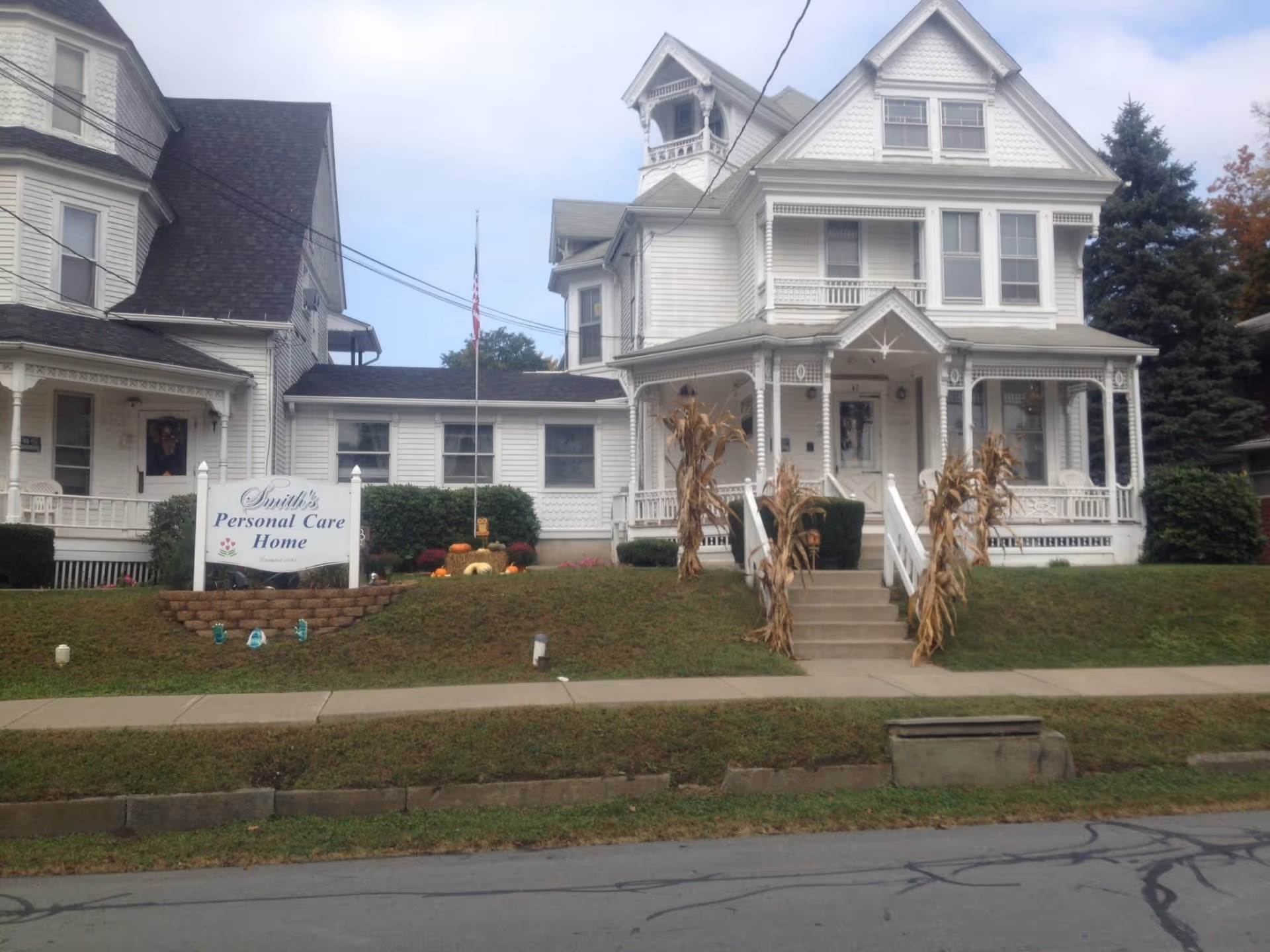 White Victorian-style house with a front porch and sign for Smith's Personal Care Home