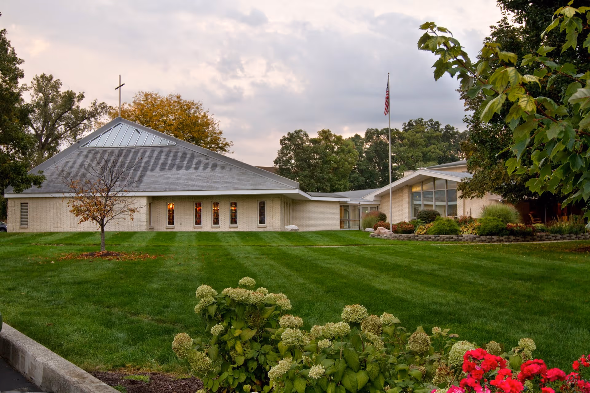 Exterior view of Saint Anne Home with a manicured lawn and flagpole