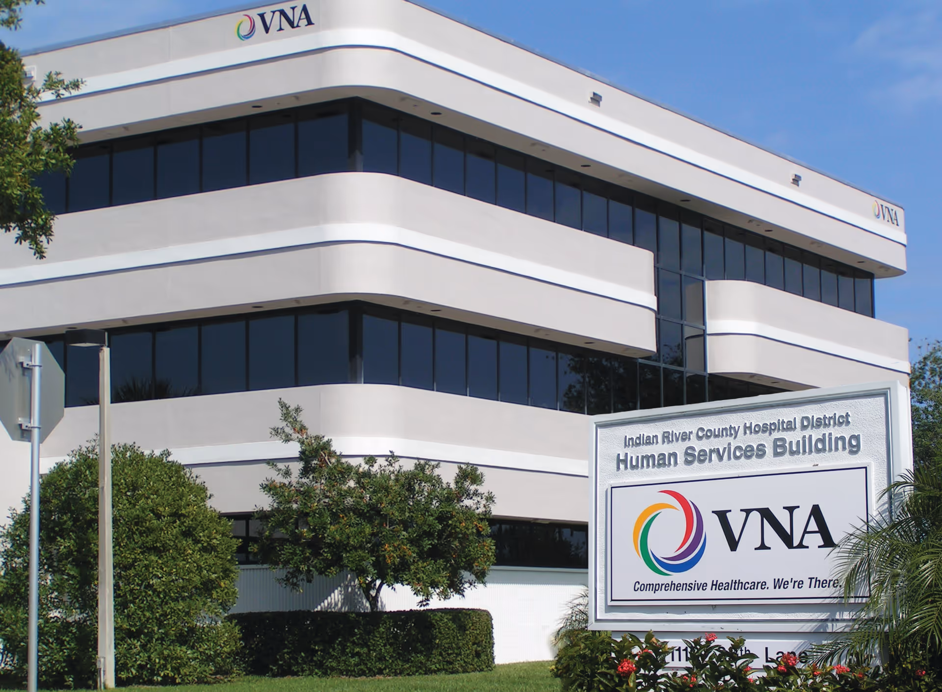 Modern white office building with VNA sign and landscaped foreground.