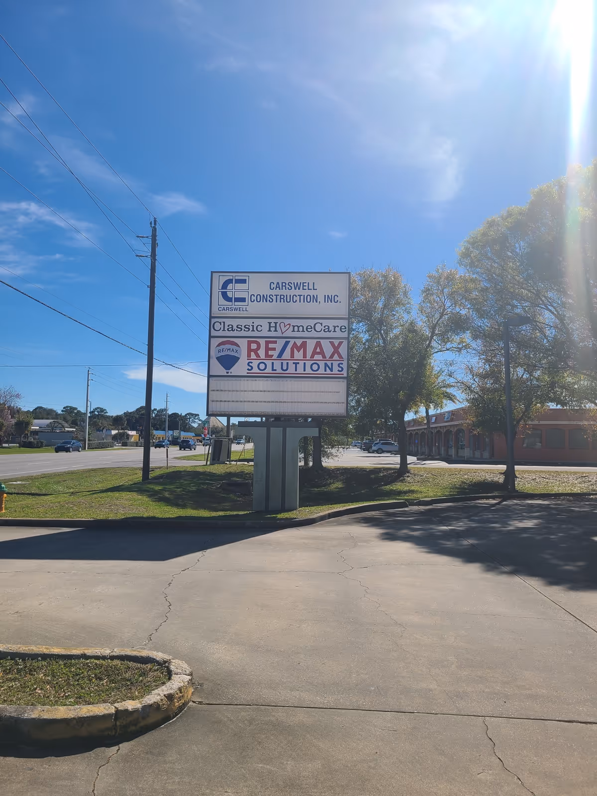 Sunny outdoor sign for Classic HomeCare with Carswell Construction and RE/MAX Solutions.