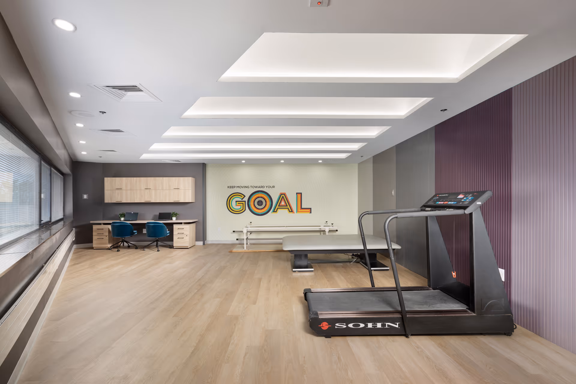 Interior fitness area with treadmill, benches, and desk space along wall.