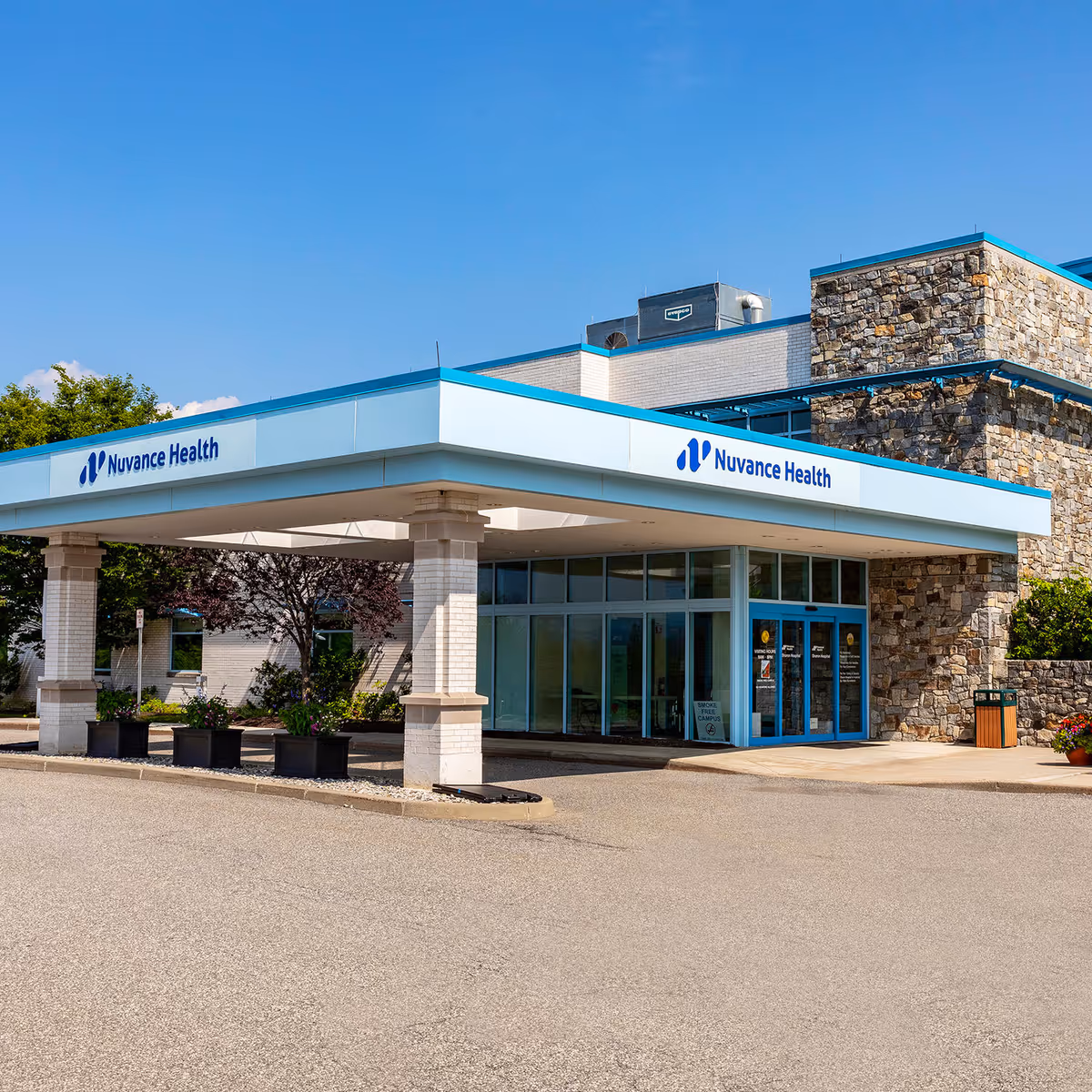 Exterior view of Nuvance Health building with glass doors and stone facade.