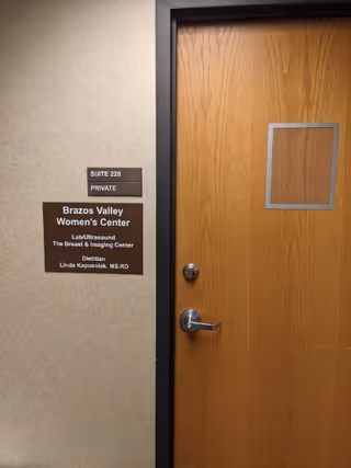 Wood door with private suite sign and Brazos Valley Women's Center Breast & Imaging plaque.