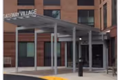Exterior view of Gateway Village entrance with a metal canopy and glass doors.