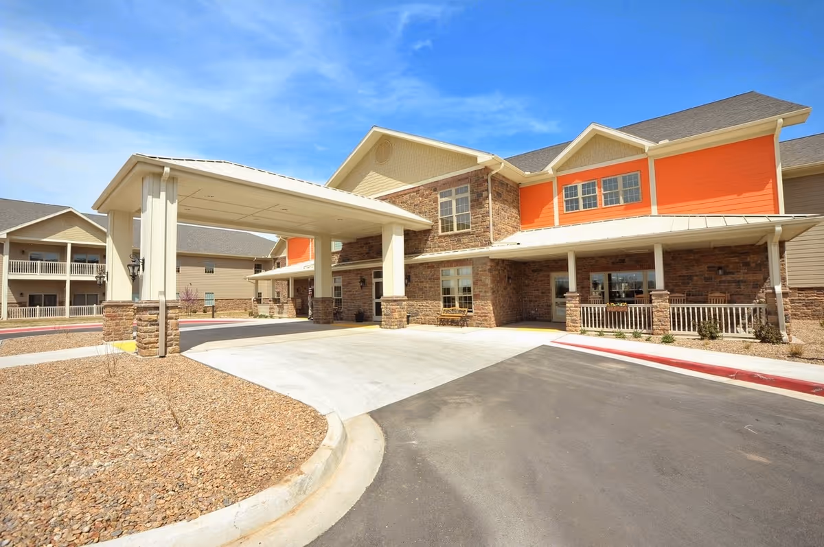 Exterior view of a senior living facility with a covered entrance.