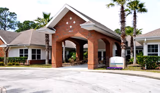 Front view of Brookdale Dr. Phillips senior living center entrance with palm trees.