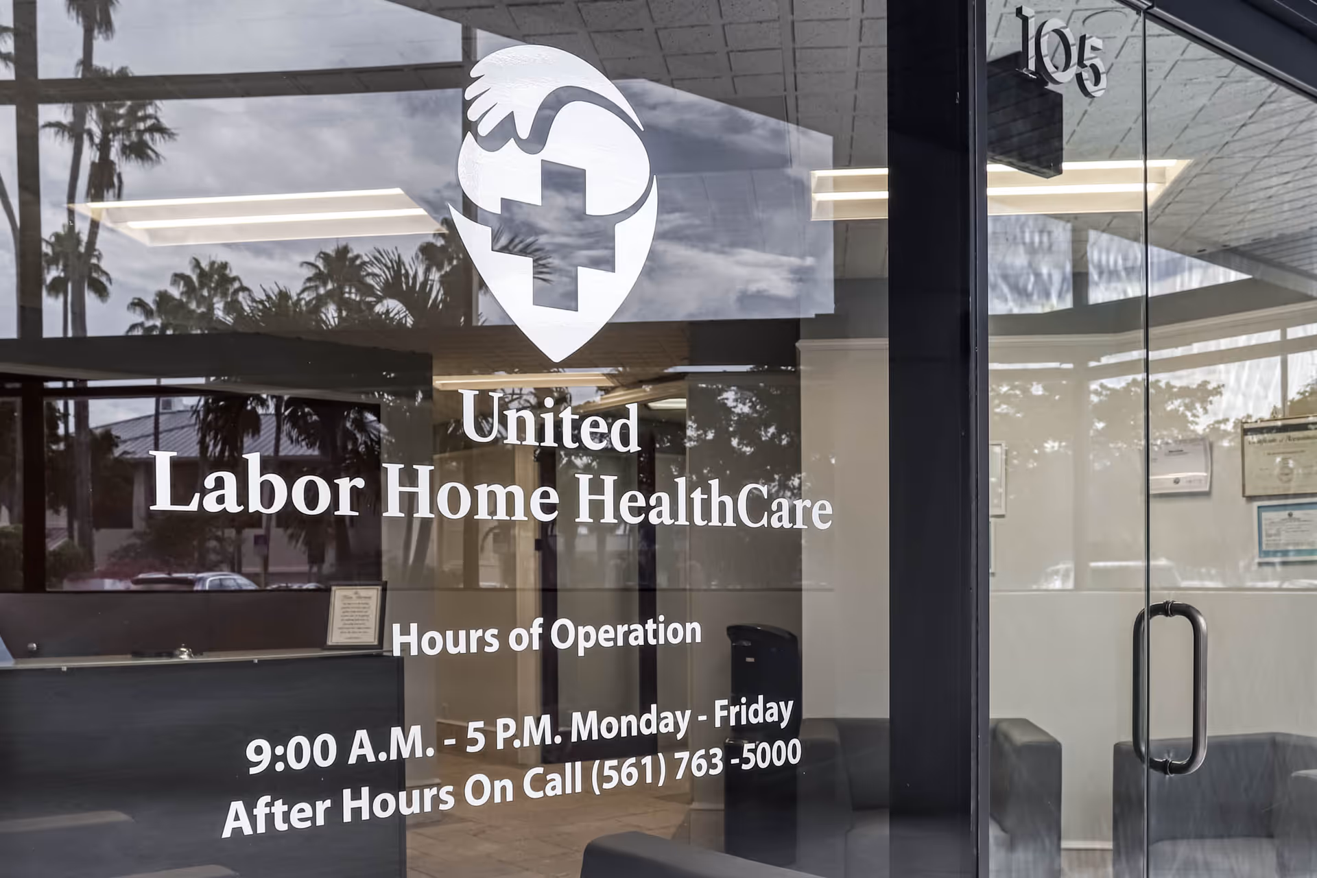 Glass storefront displaying United Labor Home HealthCare signage and hours with reflections.