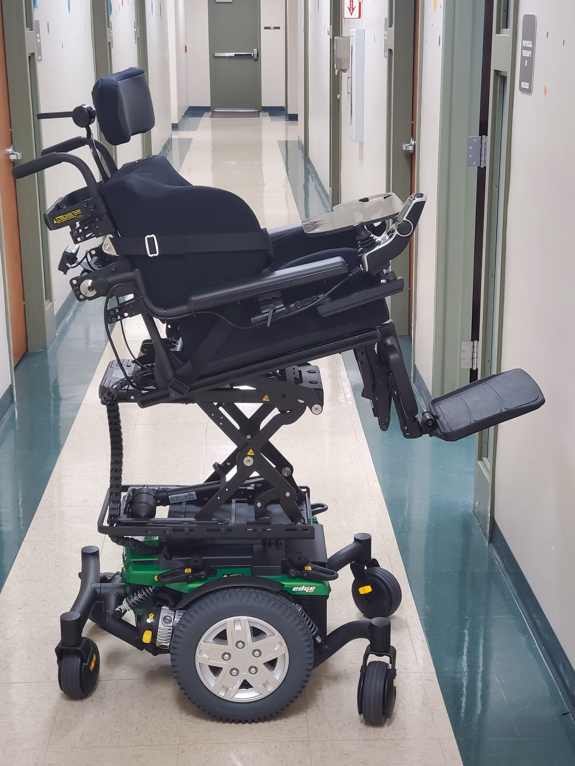 Power wheelchair in a long corridor of a senior facility.
