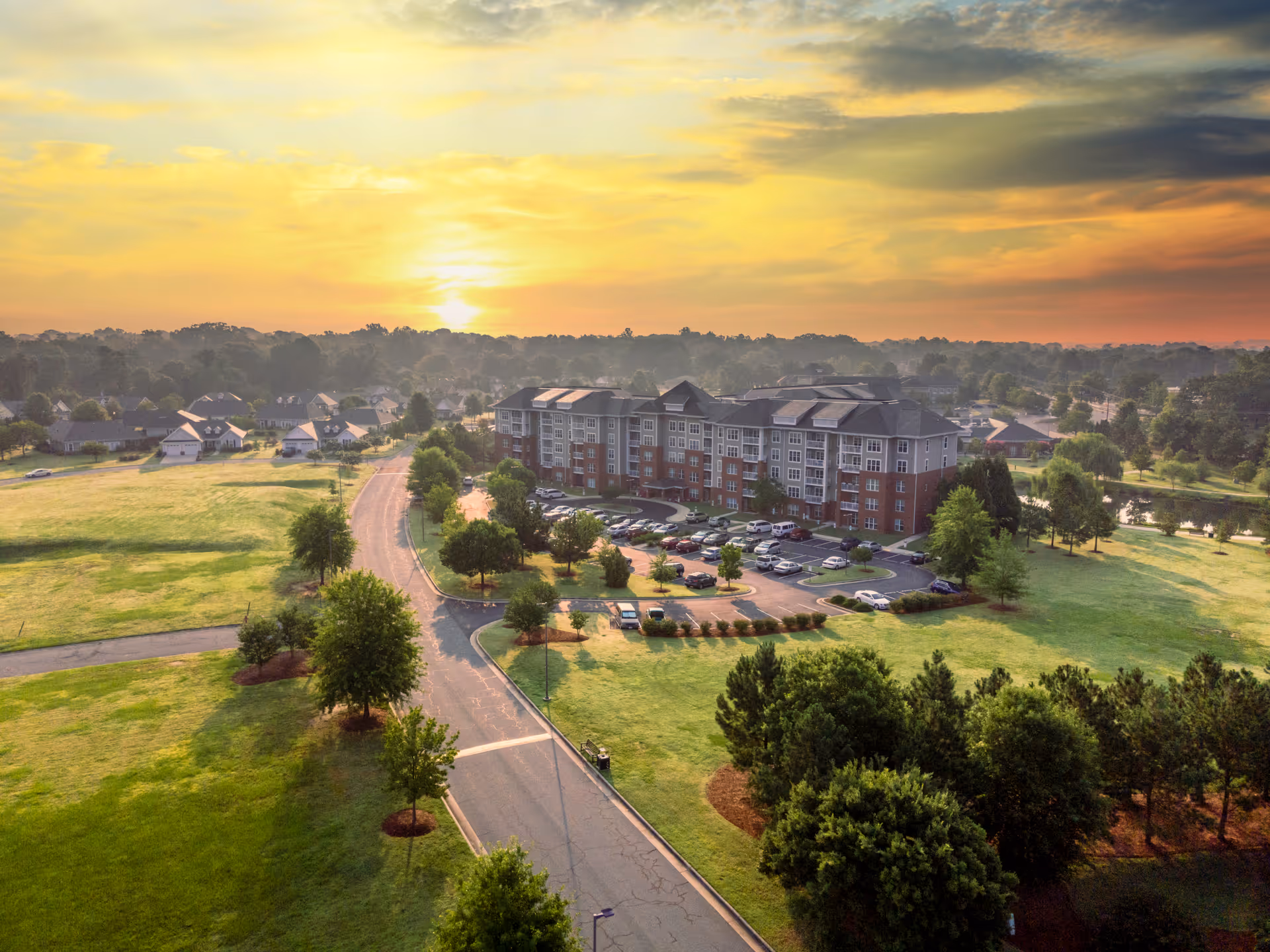 Aerial view of The Village at Brookwood campus, with a building, parking lot, and green lawns.