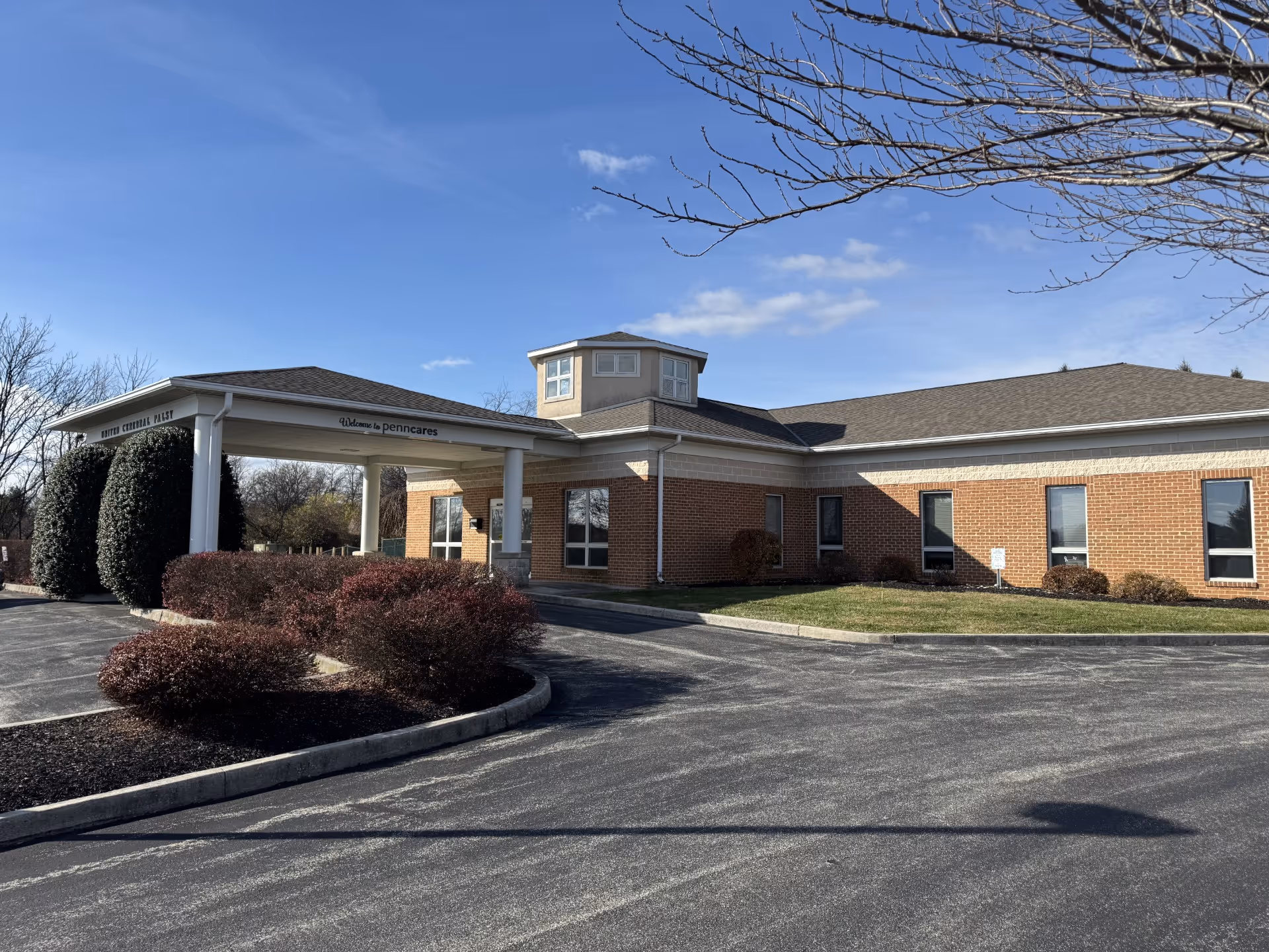 Front view of PennCares facility showing brick building and entrance canopy.