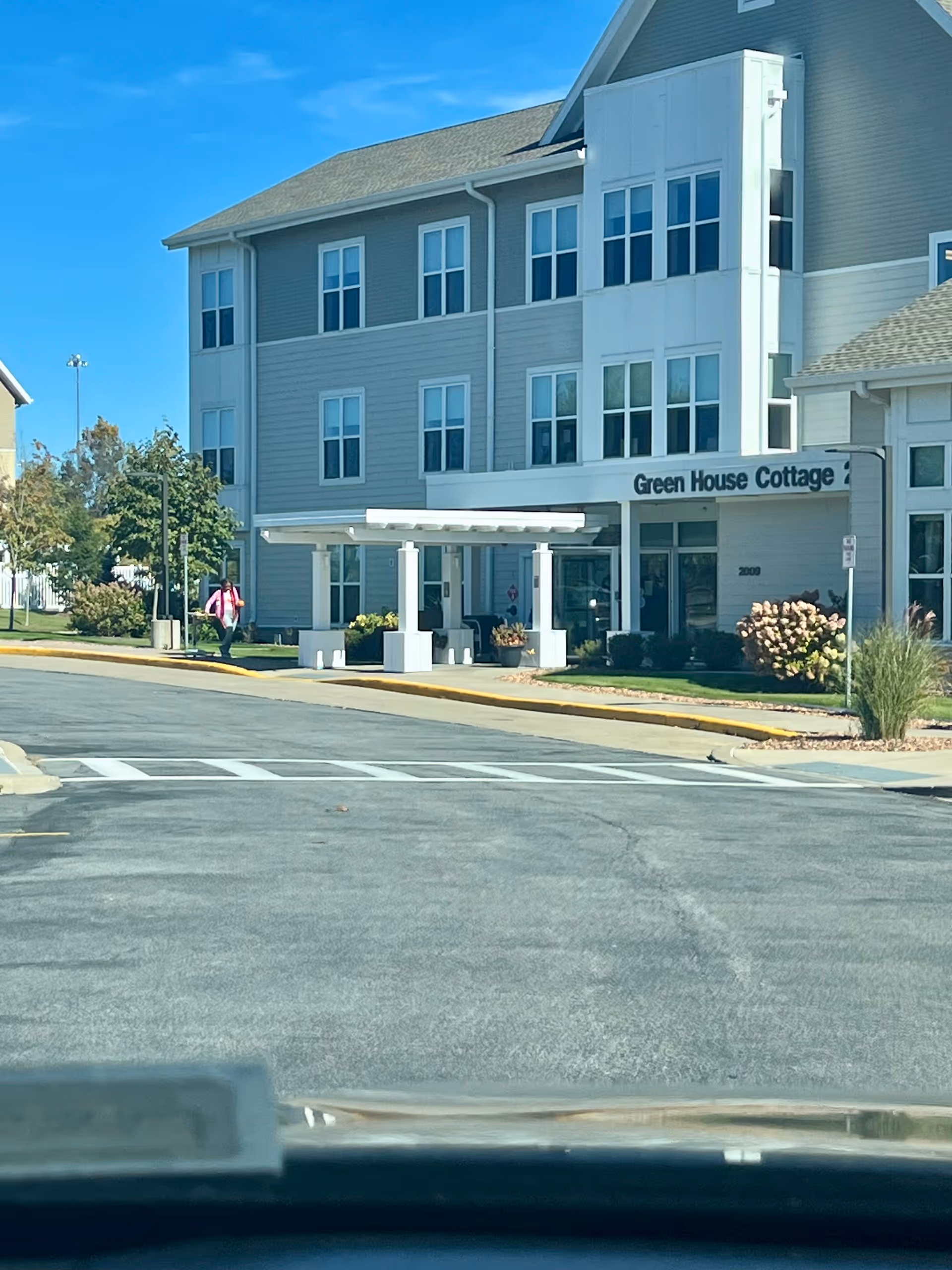 Exterior view of Green House Cottage senior living building with a covered entrance.