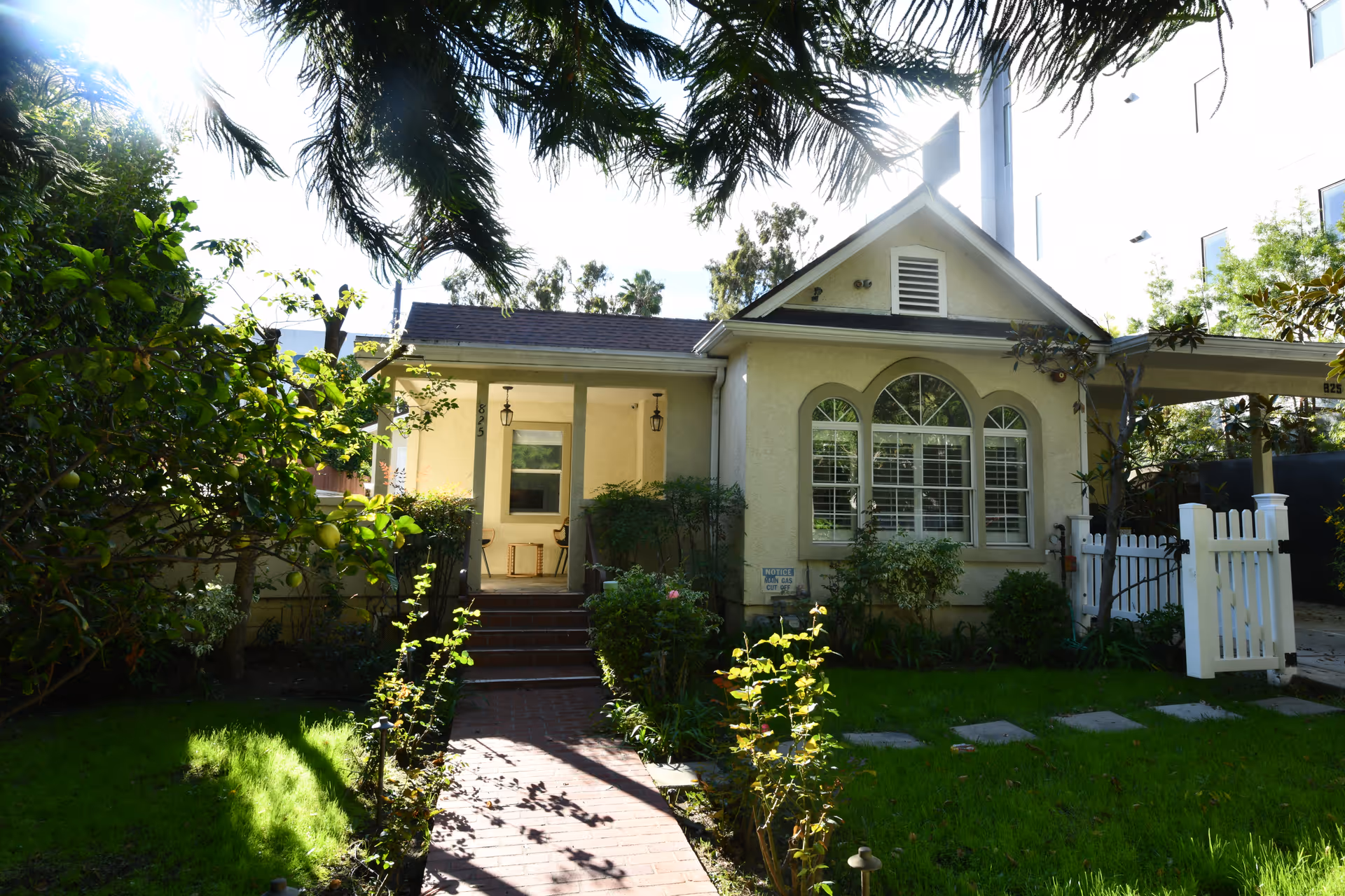 A quaint front view of Raya's Paradise senior living home with a garden