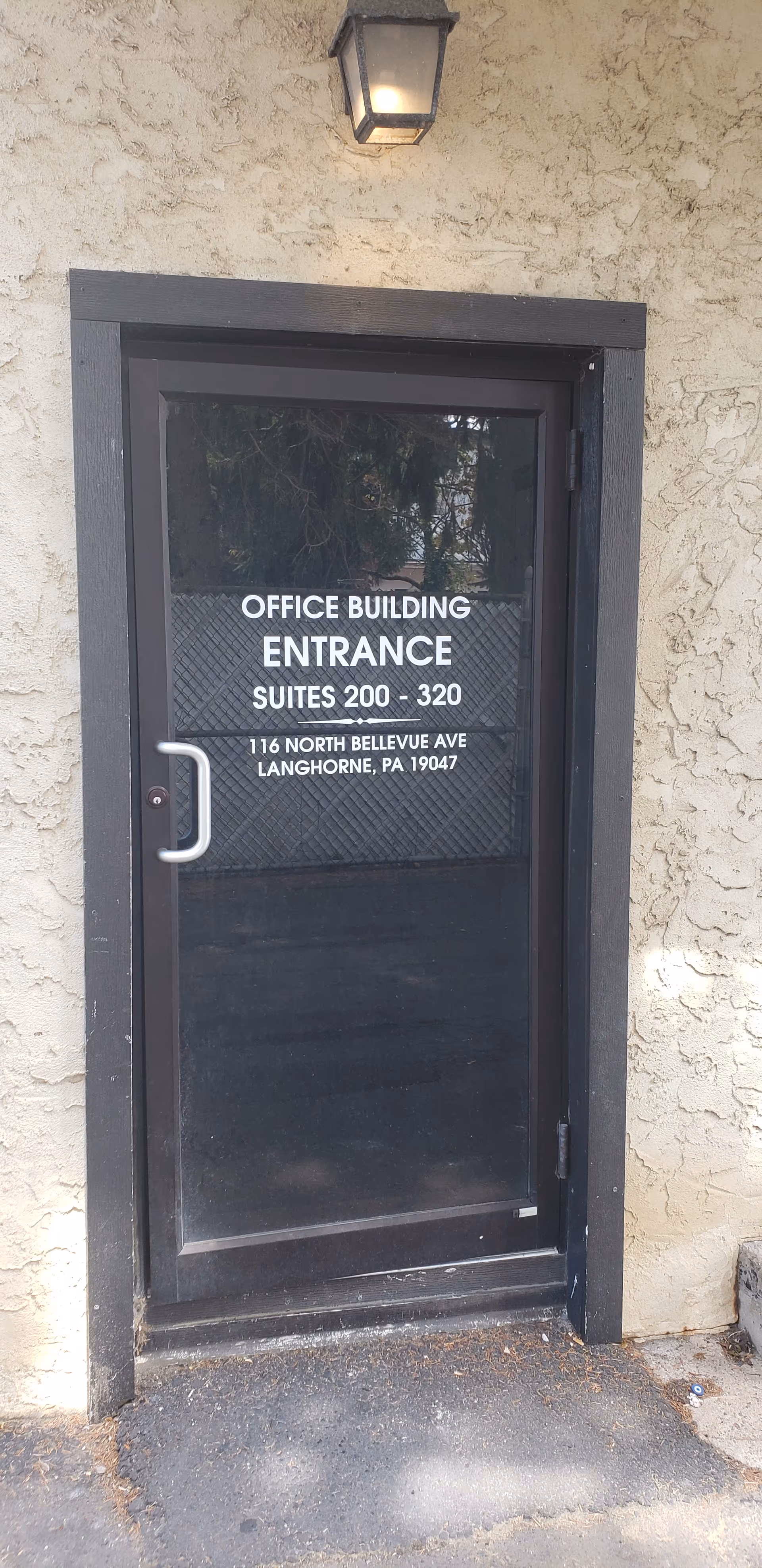 Office building entrance door with white lettering on glass panel.