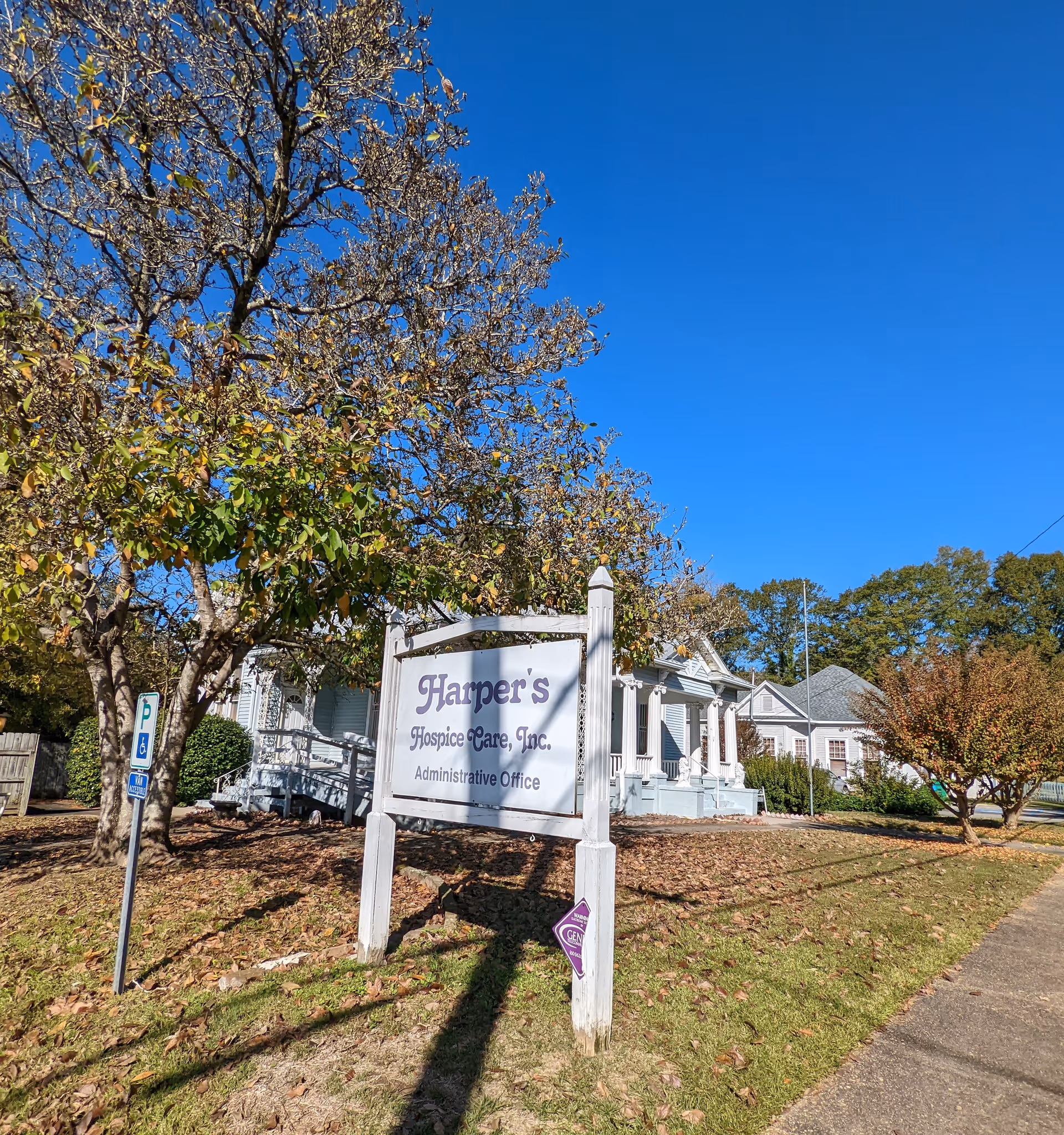 Outdoor view of Harper's Hospice Care sign beside a small building under a clear blue sky