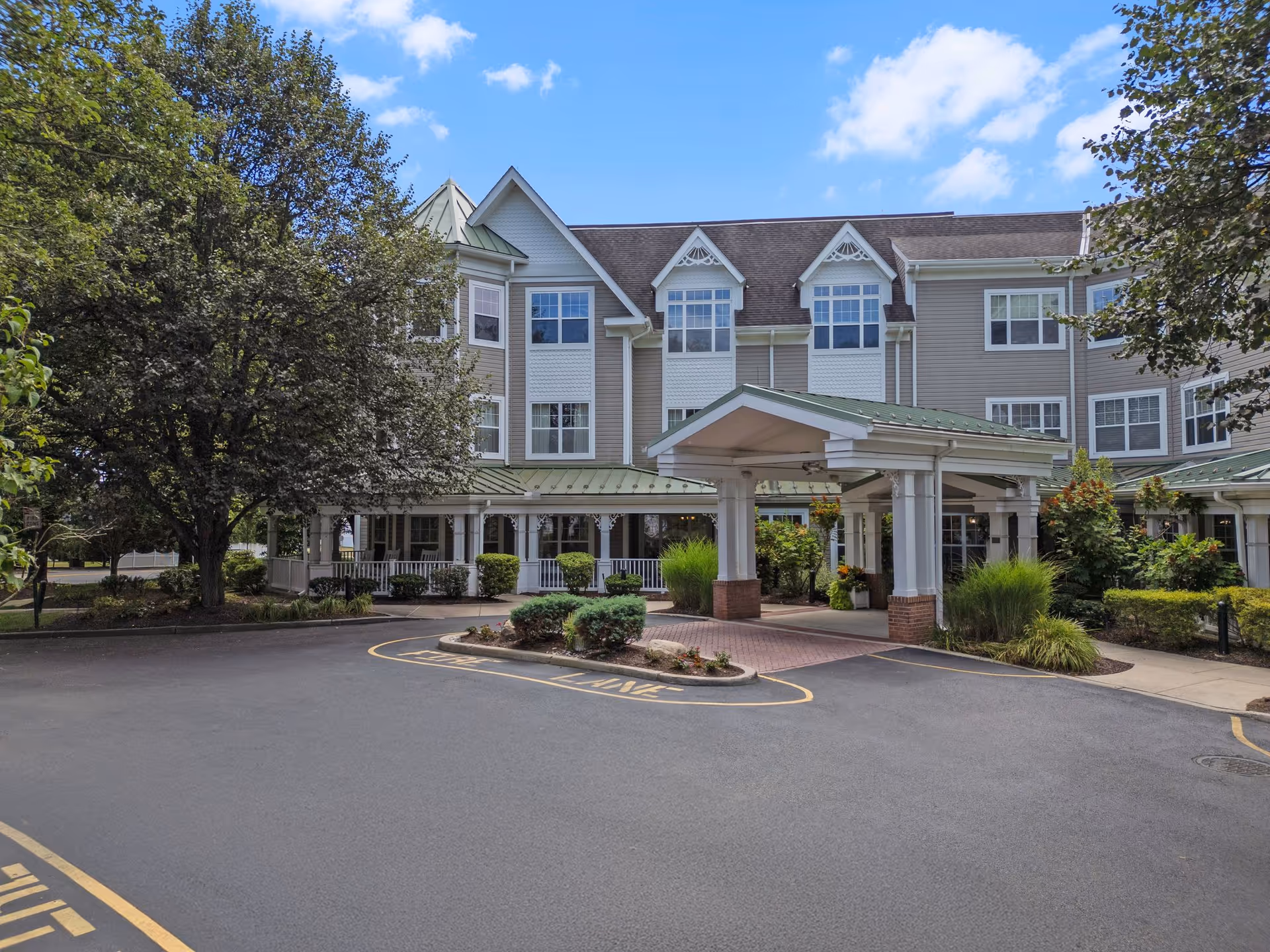 Exterior view of Sunrise of Paramus with a covered entrance and landscaped grounds.