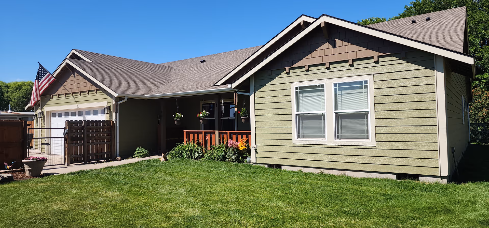 Front view of The Geneva House Adult Foster Home with a lawn, porch, and garage.