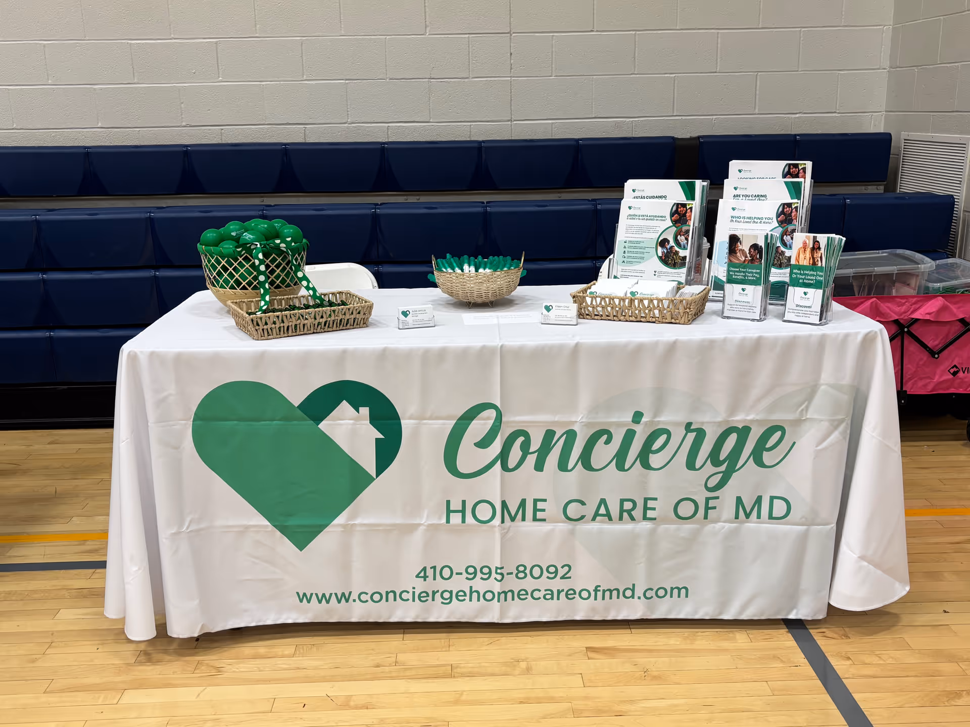 Promotional display table for Concierge Home Care of MD in a gym-like interior.