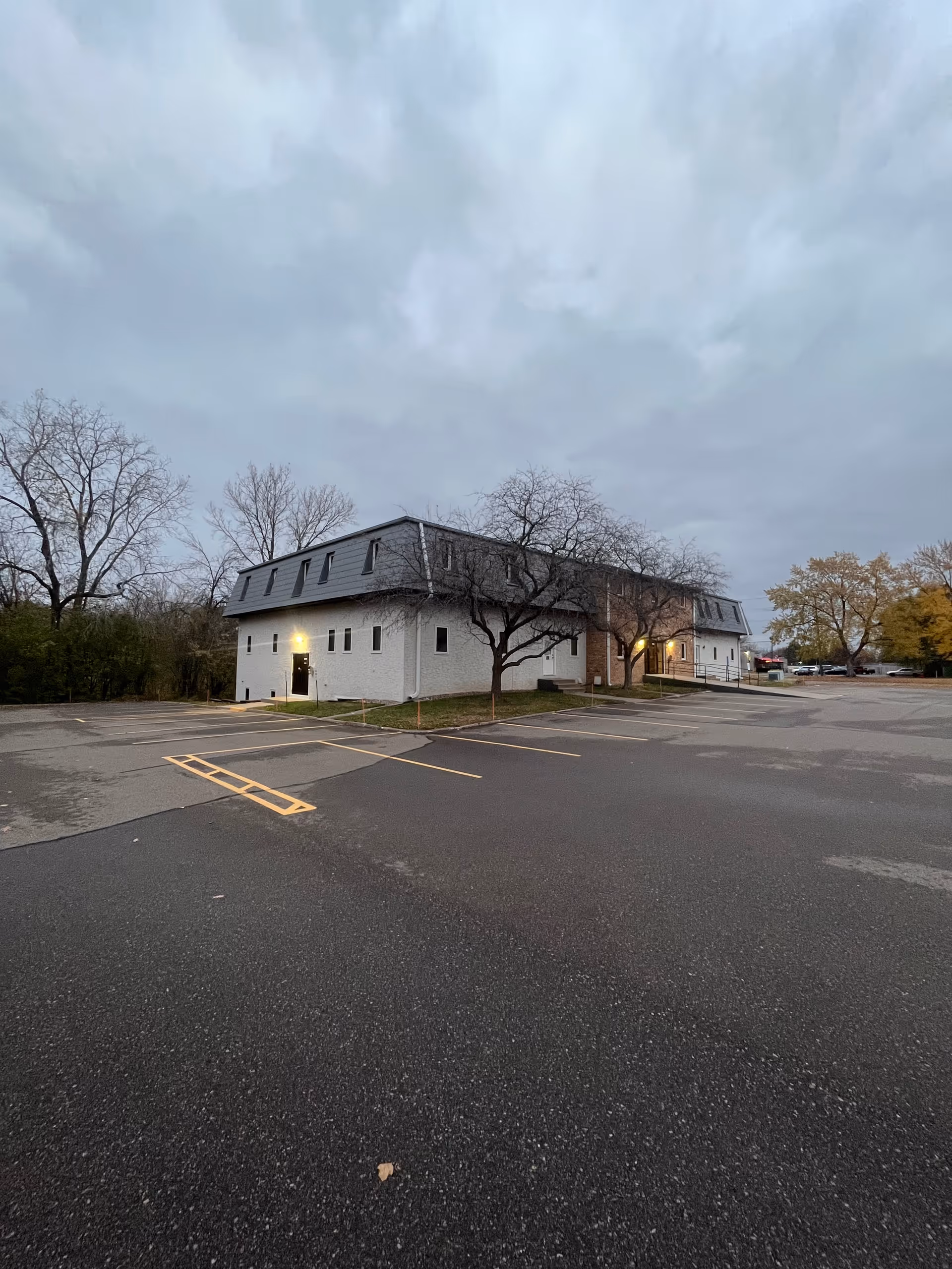 Exterior view of Minnesom Home Health Care building with parking lot and leafless trees.